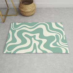 a green and white rug on the floor next to a basket