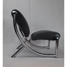 a black chair sitting on top of a metal frame next to a white wall and floor