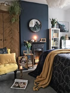 a bedroom decorated in blue and yellow with a bed, chair, fireplace and bookshelf