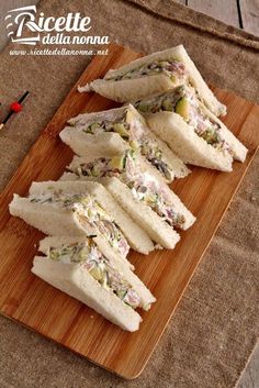 several sandwiches cut in half on a cutting board