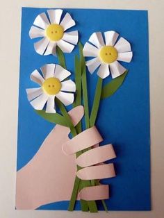 a hand holding flowers made out of paper