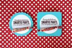 two small candy bars sitting on top of a red and white polka dot covered table