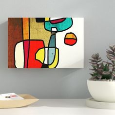 a painting hanging on the wall next to a potted plant in a white vase