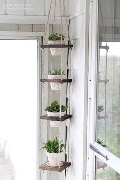 hanging planter made out of wood and rope with potted plants on the side