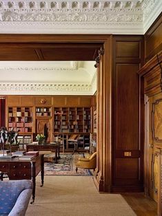 a living room filled with lots of furniture and bookshelves covered in wooden bookcases