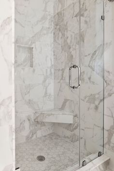 a walk in shower with marble walls and floor