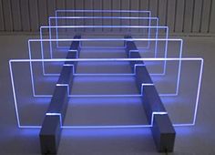 an abstract sculpture with blue lights in the shape of squares and rectangles on concrete floor