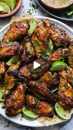 chicken wings with limes and spices on a plate