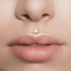 a woman's nose with a tiny gold star on the tip of her lip