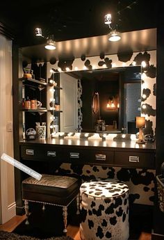 a cow print vanity with stool and lights in the mirror, along with other accessories