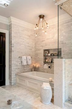 a bathroom with a large tub and chandelier hanging from it's ceiling