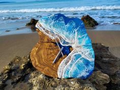 a piece of wood sitting on top of a beach next to the ocean