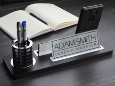 a cell phone sitting on top of a desk next to a pen holder