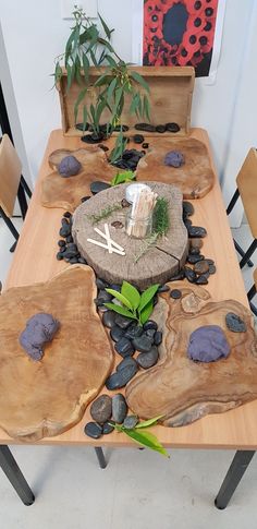 the table is made out of wood and has stones on it, along with plants