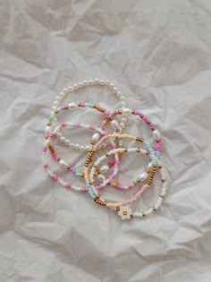 four bracelets with beads on top of white paper