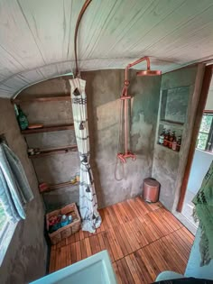 a bathroom with a shower, sink and shelves in the corner on the wall next to it