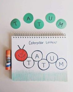 the caterpillar letters are arranged on top of a notebook with an orange marker