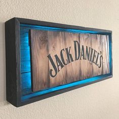 a wooden sign hanging on the side of a wall next to a blue light fixture