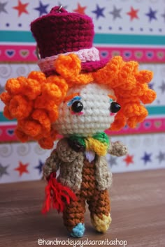 a crocheted doll with an orange hair wearing a top hat