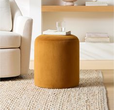 a living room with a chair, ottoman and books on the shelf next to it