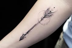 an arrow tattoo on the arm