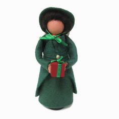 a doll with a green coat and red present