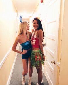 two women dressed up in costumes standing next to each other on the hallway way together