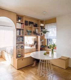 a room with bookshelves, shelves and a table in the middle of it