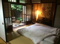 a bed sitting in a bedroom next to an open window with japanese writing on it