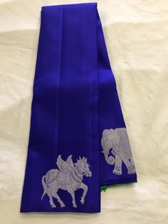 two blue napkins with elephants on them sitting on a white tablecloth covered surface