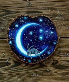 a painting of a cat sitting on top of a blue moon with stars in the sky