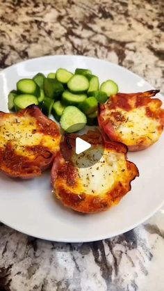 a white plate topped with cut up tomatoes and cucumber on top of a counter