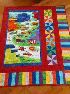 a colorful quilt is on the floor in front of a wooden chair and table topper