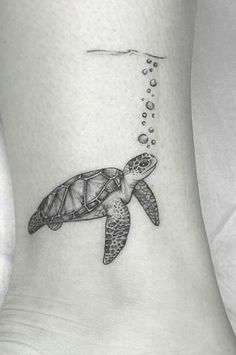 a turtle tattoo on the ankle with bubbles coming out of its head and an ocean wave coming