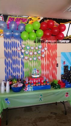 a party table with balloons, streamers and other decorations on the wall behind it