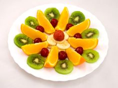 a white plate topped with sliced fruit and kiwis on top of each other