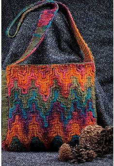 a crocheted bag sitting on top of a blue blanket