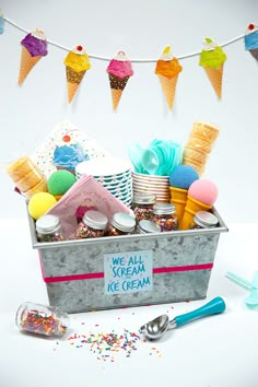 an ice cream bucket filled with lots of colorful toppings and confetti on a string