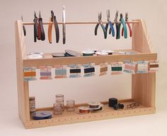 a wooden shelf with scissors and other crafting supplies