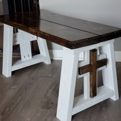 a wooden table with white legs and a cross on it