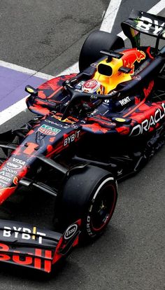 a red and black race car driving on a track