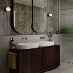 a bathroom with two sinks and mirrors on the wall