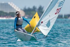 a woman is sailing in the ocean on a sailboat