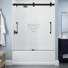 a bathroom with a walk in shower next to a white sink and blue painted walls