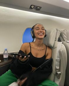 a woman sitting in an airplane with headphones on