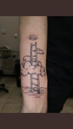 a man's arm with a ladder in the sky and clouds on it,