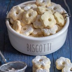 a white bowl filled with powdered sugar cookies