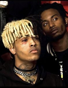 two young men with dreadlocks on their heads are posing for a photo together