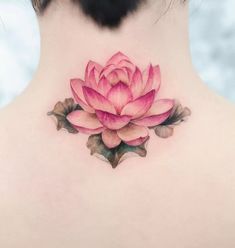 a woman's back neck with a pink flower tattoo on the upper part of her neck