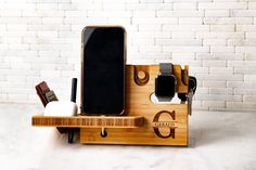 a cell phone is sitting on a wooden holder with other items in front of a brick wall